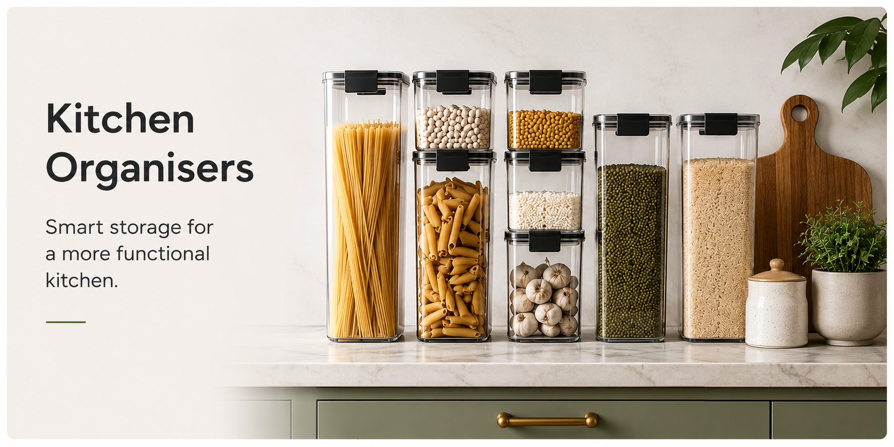 Six clear kitchen storage containers with black lids, filled with pasta, beans, grains, and garlic, arranged on a kitchen countertop with kitchen props including a cutting board, plant, and jar. Text on the left reads 'Kitchen Organisers'.